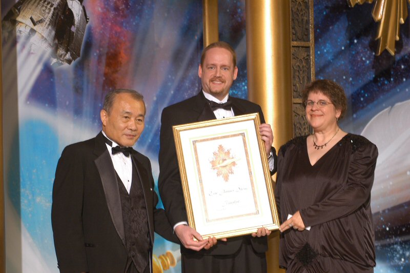 Eric James Stone receives his Writers of the Future award from judges Eric Kotani and Nina Kiriki Hoffman